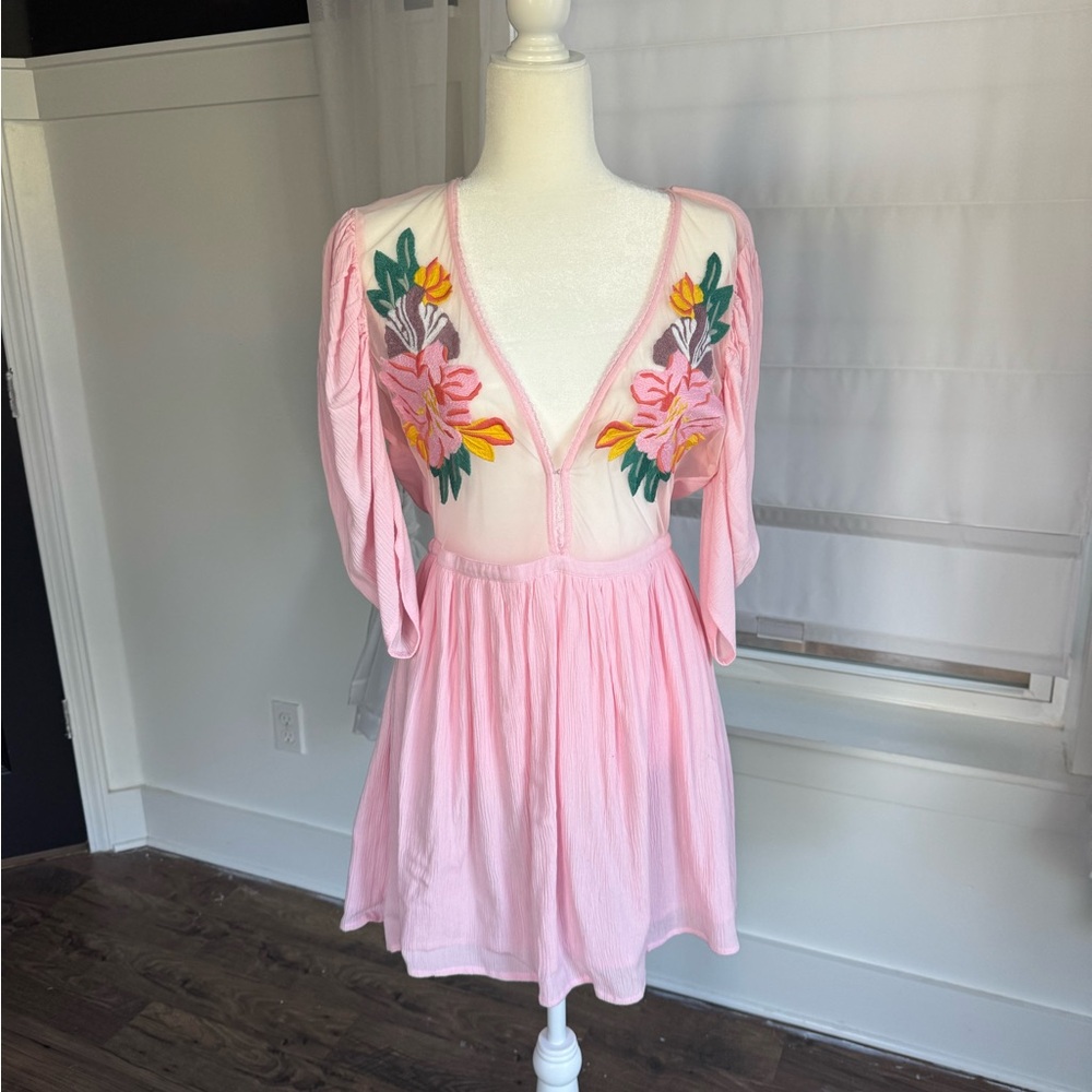 Light pink dress with delicate flower detail and sheer fabric.